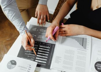 Financial professional reviewing documents with cryptocurrency graphics in the background.