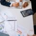 Congress members discussing financial regulations with charts and documents on the table.