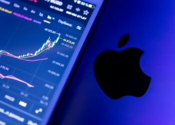 Coinbase logo displayed alongside stock charts and Yahoo Finance logo on a digital screen.