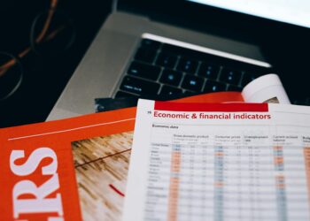 Business professionals discussing cryptocurrency regulations with financial documents on a table.