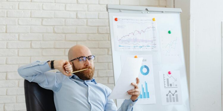 CEO at a conference table reviewing financial charts related to Bitcoin and market losses.
