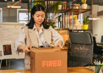 Employees in an office look concerned as news of layoffs and AI restructuring spreads.