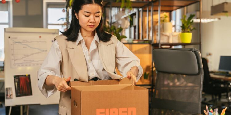 Employees in an office look concerned as news of layoffs and AI restructuring spreads.