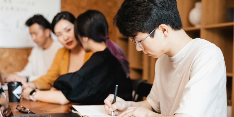 Office workers in a modern office environment, discussing job cuts amid restructuring plans.