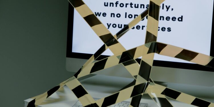 A cryptocurrency office with empty desks and layoff notices posted on walls.