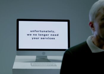 Employees at Block Inc. exit office building amidst layoffs announcement in financial sector.