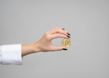 Government official examining cryptocurrency coins in a regulatory meeting.