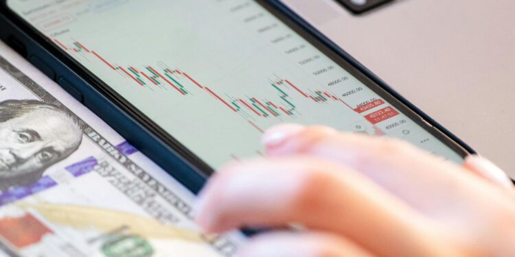 Stock market graph with upward trend, symbols of finance, and dollar signs in the background.