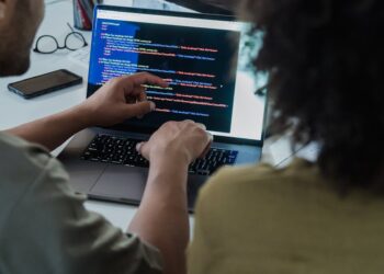 Developers collaborating on Ethereum software with code and graphs illustrating scalability solutions.