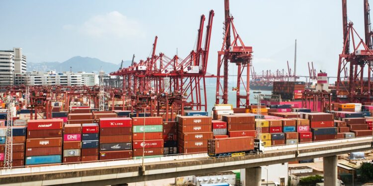 Two businessmen discuss blockchain technology at a cargo shipping terminal in Hong Kong.