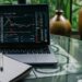 A trader examines digital stock charts on a laptop, symbolizing the rise of tokenized trading.