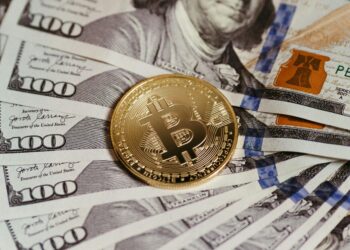 A person using a smartphone to make a cryptocurrency payment at a Brazilian market.