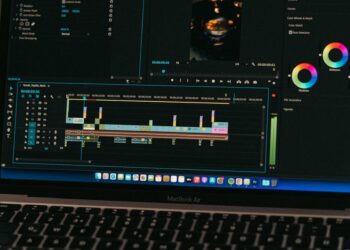 A laptop displays Sora's text-to-video interface with digital graphics in the background.