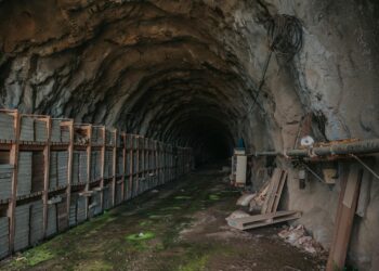 Bitcoin mining equipment in a dimly lit facility, illustrating operational challenges.