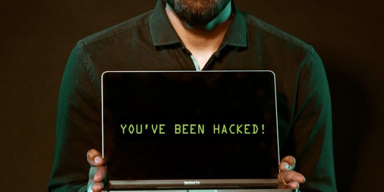 Employee laptop with a security alert on screen and cryptocurrency symbols in the background.