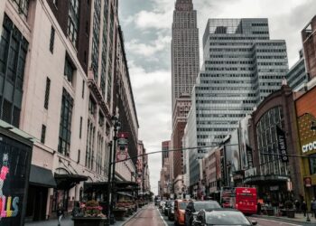 Modern office building in NYC with Ledger branding and a bustling urban backdrop.