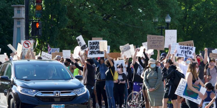 A group of individuals holding signs outside JPMorgan Chase protesting a Ponzi scheme.