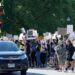 A group of individuals holding signs outside JPMorgan Chase protesting a Ponzi scheme.