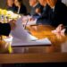 Lobbyists discuss regulations at a conference table, papers and devices on display.