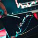 A person analyzes cryptocurrency charts on a computer screen with regulatory documents nearby.