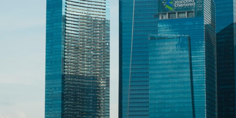 HSBC and Standard Chartered logos with cryptocurrency icons and Hong Kong skyline.