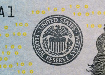 A graphic depicting a digital currency symbol with financial charts and a federal reserve building.