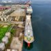 Cargo ships in a busy harbor, symbolizing oil trade and potential regulatory changes.