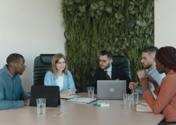 Banking professionals discuss cryptocurrency custody solutions at a conference table.