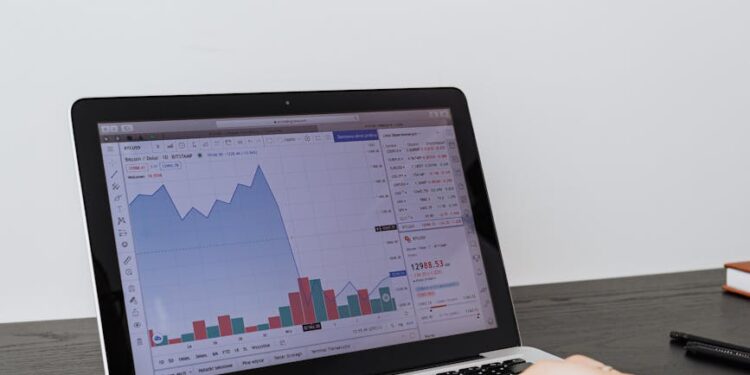 Individuals working on computers with graphs and cryptocurrency symbols displayed.