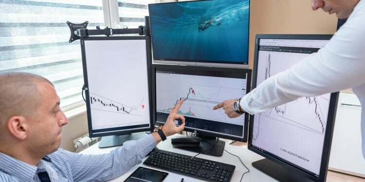 Traders analyzing cryptocurrency charts on multiple screens with finance data displayed.