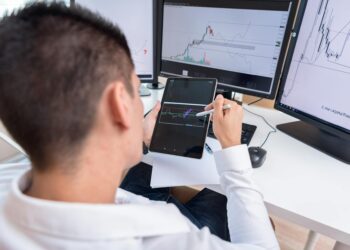 A financial analyst reviewing charts on a digital display related to crypto profits.