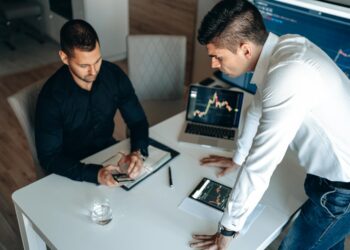 A trader reviews cryptocurrency graphs with a worried expression and Aave logo in the background.