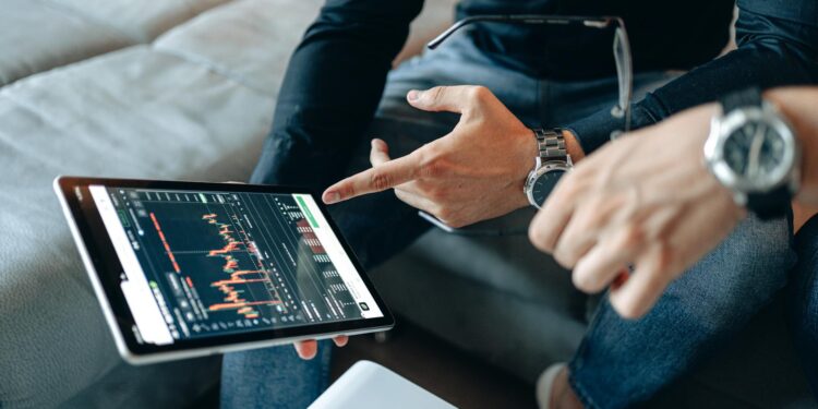 Individuals analyzing cryptocurrency transactions on a digital screen with graphs.