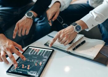 Investors and financial professionals discussing Bitcoin finance in a modern office setting.