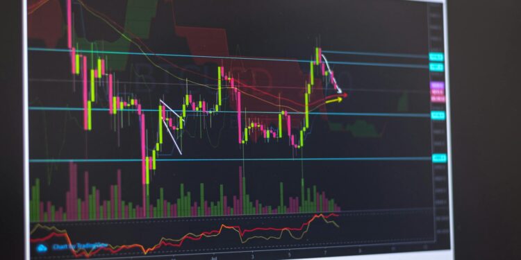 Investor anxiously stares at a computer screen displaying fluctuating cryptocurrency values.