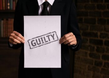 Courtroom scene with a man in a suit admitting guilt related to music royalties fraud.