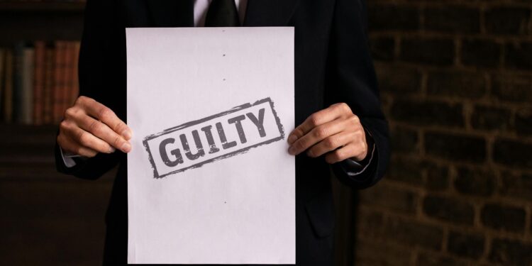 Courtroom scene with a man in a suit admitting guilt related to music royalties fraud.