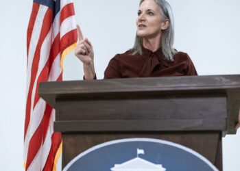 Dario Amodei speaking at a podium, discussing AI regulations and Pentagon policies.