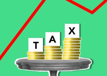 Bitcoin coins stacked on a table with a rising graph in the background, symbolizing growth.