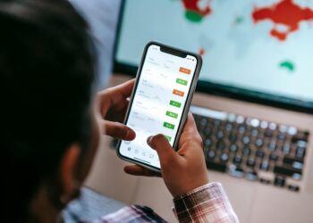 Traders analyze stock trends on digital screens in a busy finance office.