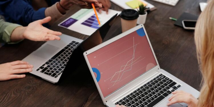A modern office setting with team members discussing blockchain technology over laptops.