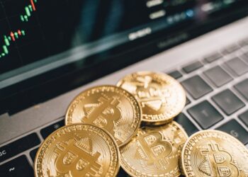 Agents investigating digital currencies on laptops surrounded by crypto symbols and financial charts.