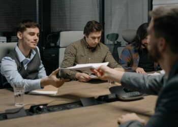 A conference table with documents and digital currency symbols, discussing stablecoin regulation.
