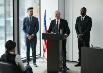 Justin Sun speaking at a podium during the DC Blockchain Summit on crypto policy initiatives.