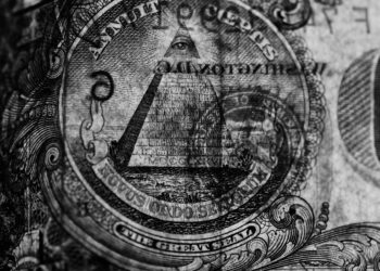 Visual representation of cryptocurrency symbols with a U.S. Treasury seal and barbed wire backdrop.