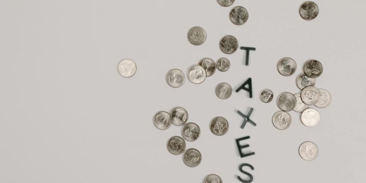 Graphic showing cryptocurrency coins with a tax symbol overlay, highlighting new regulations.