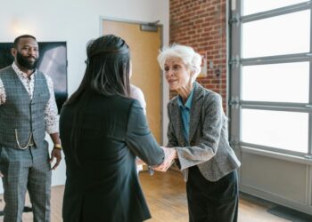 Investors discussing funding at a tech conference with AI and manufacturing visuals in the background.