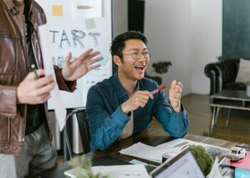 Investors discussing funding with cryptocurrencies displayed on screens in the background.