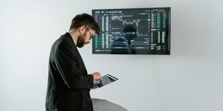 A financial analyst discusses cryptocurrency regulations with XRP graphics displayed on a screen.