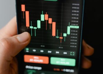 A person reviews cryptocurrency betting options on a digital screen with financial graphs.